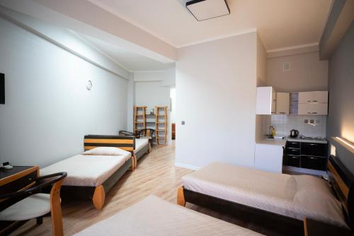 a room with three beds and a kitchen at Tsolmon's Serviced Apartments in Ulaanbaatar