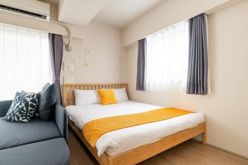 a small bedroom with a bed and a blue couch at Akasaka Residence in Tokyo