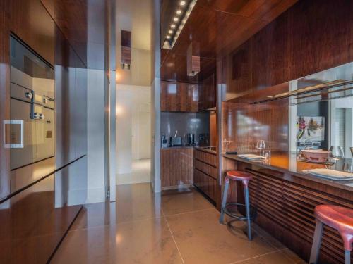 une cuisine avec des murs en bois et un comptoir avec un tabouret dans l'établissement Courchevel : Appartement 2 Chambres Avec Parking et WIFI - FR-1-563-160, à Courchevel