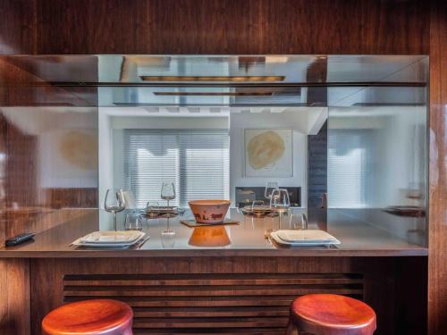 un comptoir avec deux tabourets et une table avec des verres à vin dans l'établissement Courchevel : Appartement 2 Chambres Avec Parking et WIFI - FR-1-563-160, à Courchevel