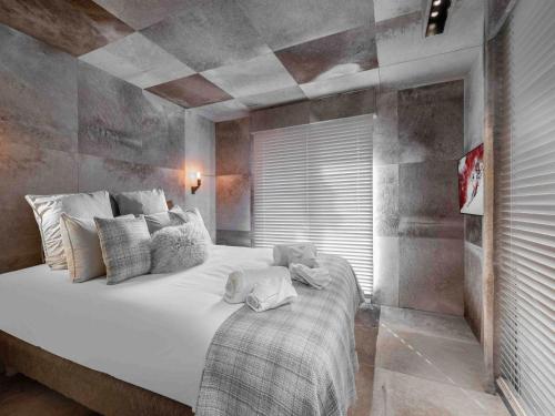 une chambre avec un grand lit blanc dans une pièce dans l'établissement Courchevel : Appartement 2 Chambres Avec Parking et WIFI - FR-1-563-160, à Courchevel