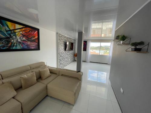 a living room with a couch and a painting on the wall at Hotel Las Vegas in Guatapé