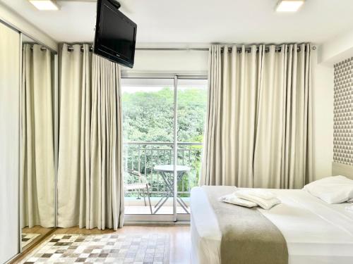 a bedroom with a bed and a large window at Flat WiseSP - Expo Anhembi in Sao Paulo