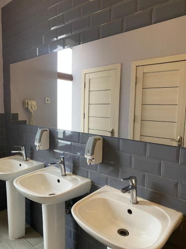 a bathroom with two sinks and a mirror at Central Hostel in Sheki