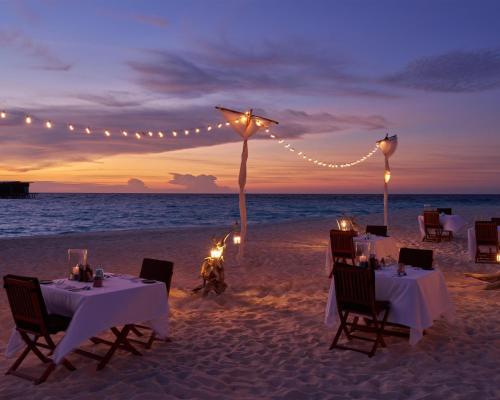 a dinner table on the beach with lights and candles at Park Hyatt Maldives Hadahaa in Gaafu Alifu Atoll