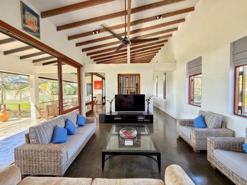 a living room with two couches and a tv at Villa Margot by Ceylon Spaces in Pamunugama