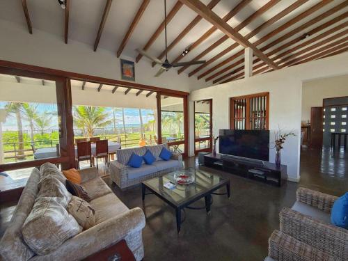 a living room with two couches and a television at Villa Margot by Ceylon Spaces in Pamunugama