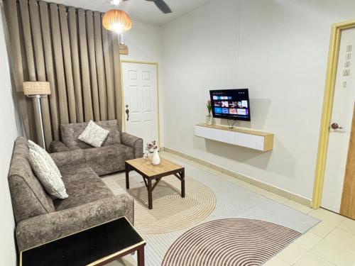 a living room with a couch and a tv at AL Rico Homestay KLIA SEPANG in Sepang
