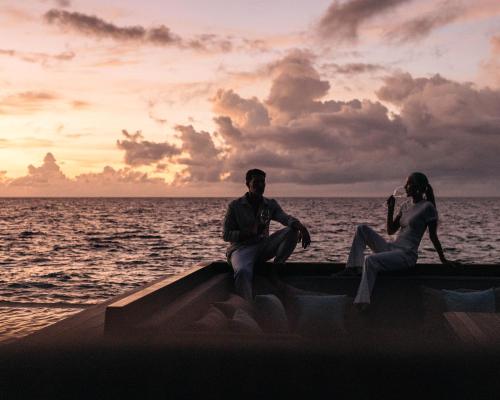 a man and a woman sitting on a boat in the ocean at Park Hyatt Maldives Hadahaa in Gaafu Alifu Atoll