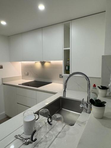 a kitchen counter with a sink and glasses on it at Serenity House in Bournemouth