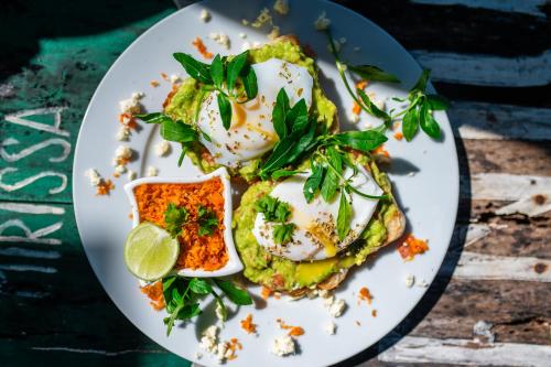 un plato de comida con huevos y verduras en una mesa en Elements Ahangama, en Ahangama