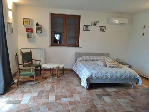 a bedroom with a bed and a table and a chair at Chicco di grano in Foiano della Chiana