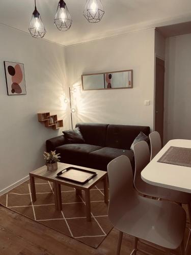 un salon avec un canapé et une table dans l'établissement Appartement moderne Wifi Fibre et Parking privé gratuit avec balcon et ascenseur, à Niort