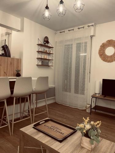 un salon avec une table et quelques chaises dans l'établissement Appartement moderne Wifi Fibre et Parking privé gratuit avec balcon et ascenseur, à Niort