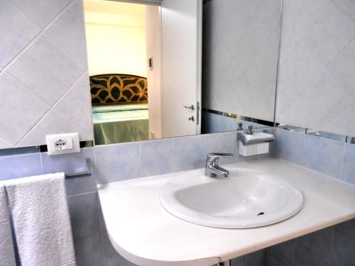 ein Bad mit einem Waschbecken und einem Spiegel in der Unterkunft Affittacamere Da Angela in Villasimius