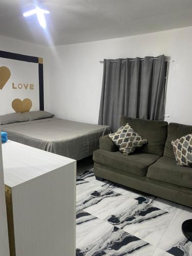 a living room with a couch and a bed at White Room Sparks in Spanish Town