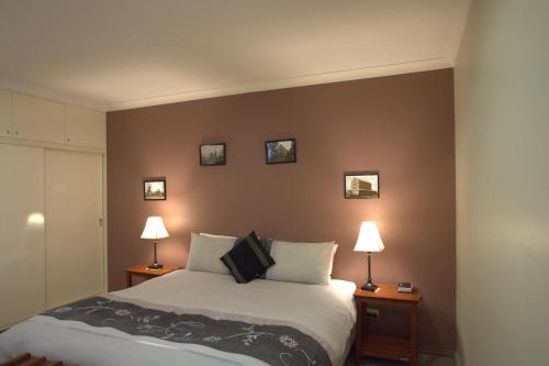 Milawa的住宿－米拉瓦馬斯喀特住宿加早餐旅館，卧室配有一张床,墙上有三幅照片