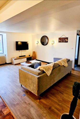 un salon avec un canapé et une télévision à écran plat dans l'établissement Le Gîte de la Crégut, à Trémouille