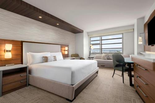 a bedroom with a bed and a desk and a couch at JW Marriott, Anaheim Resort in Anaheim