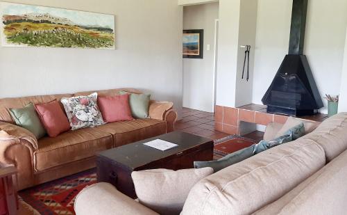 a living room with two couches and a fireplace at Schaefers' Halt in Dullstroom