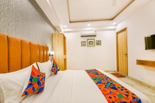 a bedroom with a bed with colorful pillows on it at FabHotel Tree House - Nr Yashobhoomi Convention Centre in New Delhi