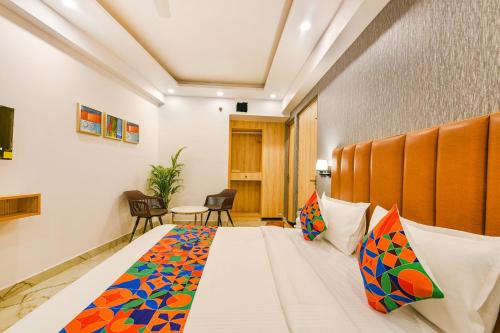 a hotel room with a large bed with colorful pillows at FabHotel Tree House - Nr Yashobhoomi Convention Centre in New Delhi