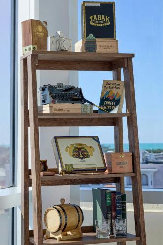 a wooden shelf with books and a laptop on it at La Concha Key West, Autograph Collection in Key West