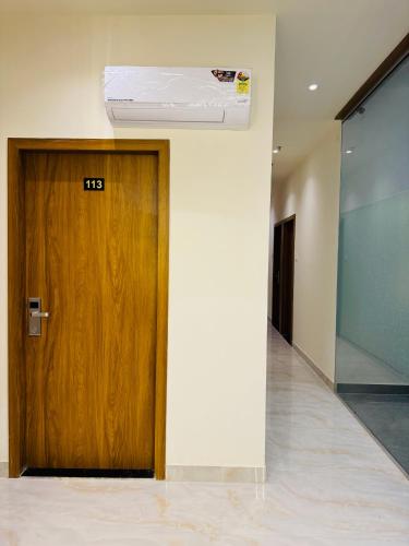 a room with a wooden door with a air conditioner above it at Hotel Bellamont in Mumbai