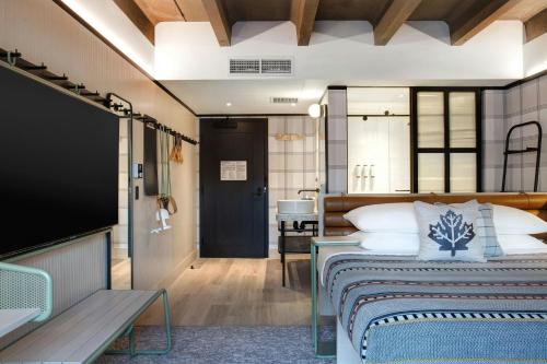 a bedroom with a bed and a flat screen tv at Moxy Banff in Banff