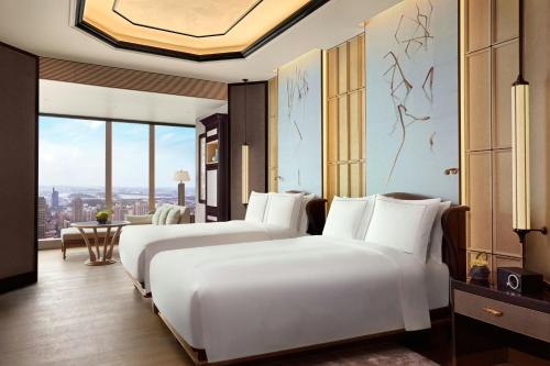 two beds in a hotel room with a view at The Ritz-Carlton, Nanjing in Nanjing