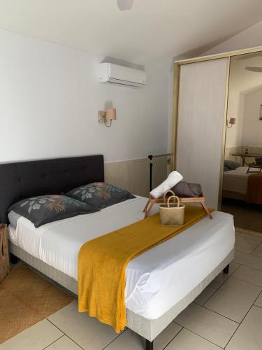 una camera da letto con un letto con una coperta gialla sopra di Bungalow Les Coraux a La Saline Le Bains