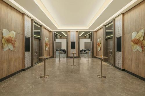 a lobby with a row of stalls with flowers on the walls at Palm Garden Hotel, Putrajaya, a Tribute Portfolio Hotel in Putrajaya