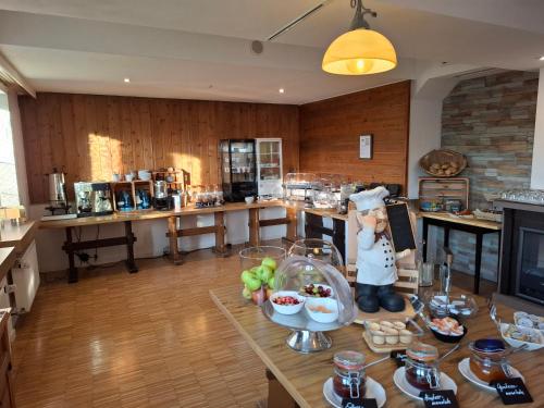 a kitchen with a table with a statue of a chef at Hotel Scharfes Eck in Mühlacker