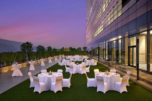 a room with tables and chairs on the roof of a building at Marriott Executive Apartments Navi Mumbai in Navi Mumbai