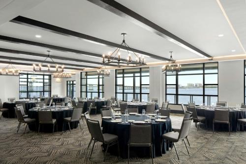 a banquet hall with tables and chairs and windows at Luminary Hotel & Co., Autograph Collection in Fort Myers