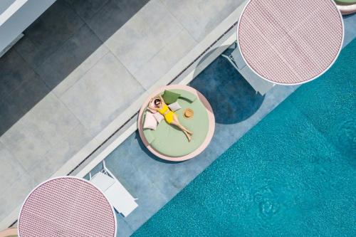 an overhead view of a woman laying on a chaise pool at Veranda Resort Phuket, Autograph Collection in Panwa Beach