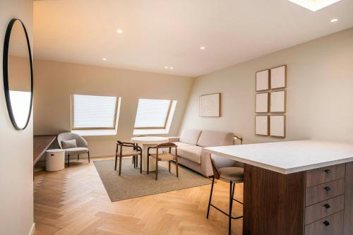 a living room with a couch and a table and chairs at Marriott Executive Apartments Brussels in Brussels