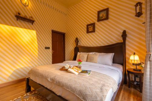 a bedroom with a bed with a book on it at Seclude Tea Estate, Palampur in Pālampur