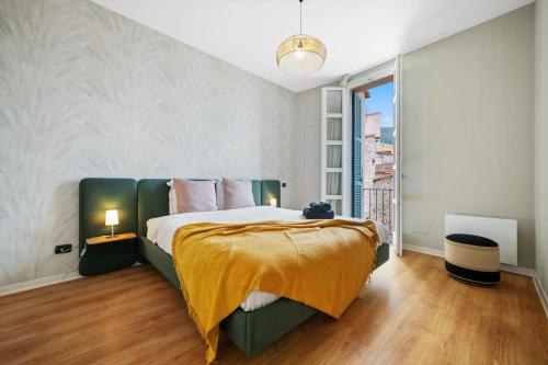 une chambre avec un grand lit avec une couverture jaune dans l'établissement Le Saint Michel,dernier étage, vieux Menton, zone piétonne, à Menton