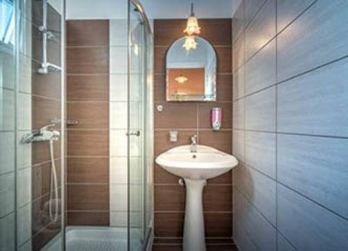 een badkamer met een wastafel en een glazen douche bij The Dream Hotel in Tragaki