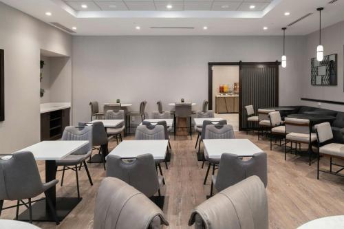 a dining room with tables and chairs and a bar at Fairfield by Marriott Inn & Suites Framingham in Framingham