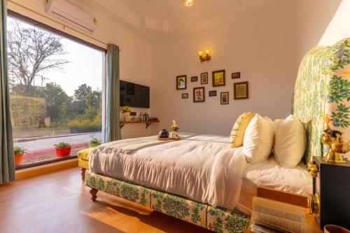 a bedroom with a bed and a large window at Seclude Tea Estate, Palampur in Pālampur