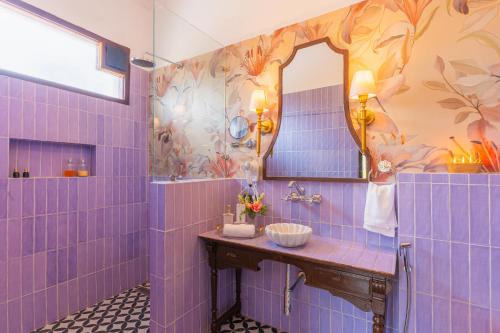 a blue tiled bathroom with a sink and a mirror at Seclude Tea Estate, Palampur in Pālampur