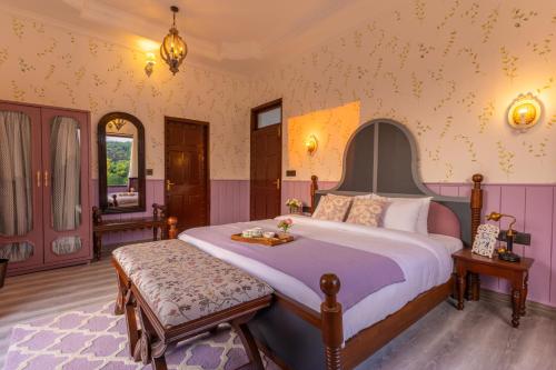 a bedroom with a large bed with purple walls at Seclude Tea Estate, Palampur in Pālampur