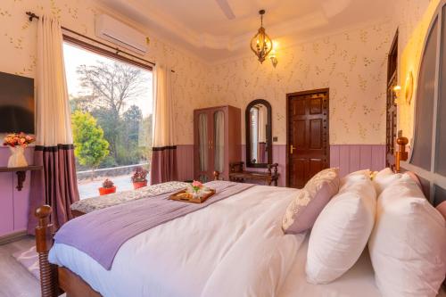 a bedroom with a large white bed with a window at Seclude Tea Estate, Palampur in Pālampur