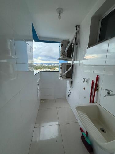 a white bathroom with a sink and a window at Apartamento Frente à Praia da Graciosa in Palmas