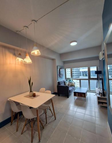 a dining room and living room with a table and chairs at 1BR Condotel - Forbeswood Parklane near St Lukes BGC Taguig in Manila