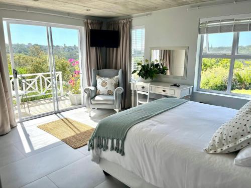 a bedroom with a bed and a chair and a window at The Pijper House - Brackenridge Eco Estate Plettenberg Bay in Plettenberg Bay