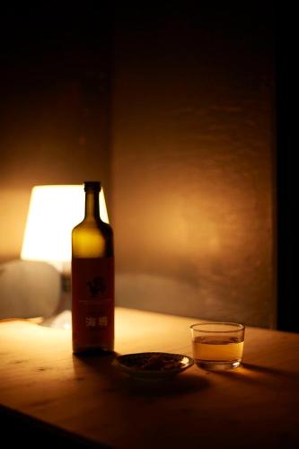 a bottle of wine and a glass on a table at KARASUYA GuestHouse in Takasaki