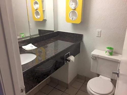 a bathroom with a sink and a toilet and a mirror at Motel 6-Waco, TX in Waco